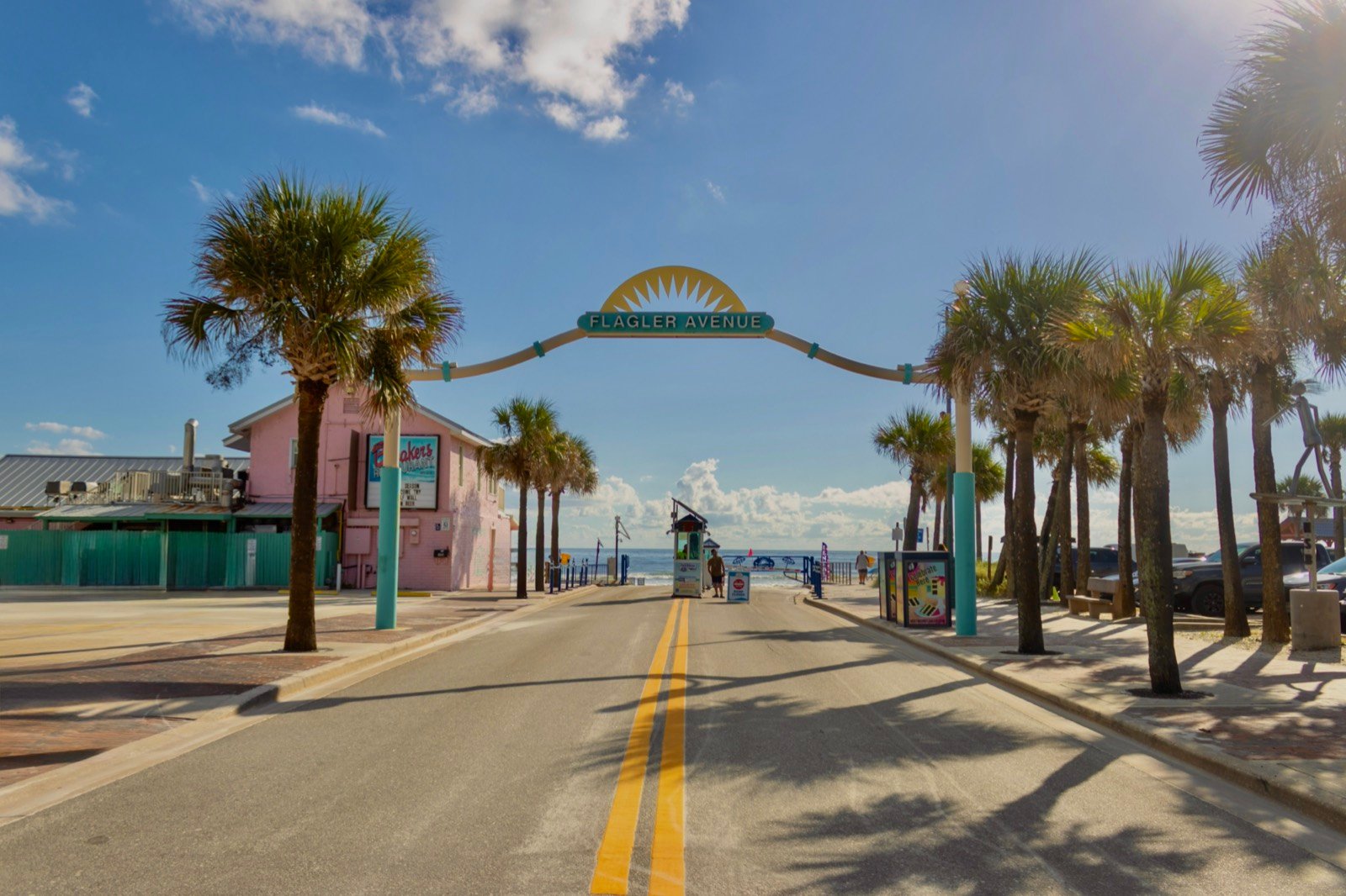 The entrance to Flagler Avenue with the pink Breakers building, palm trees, and the ocean beyond