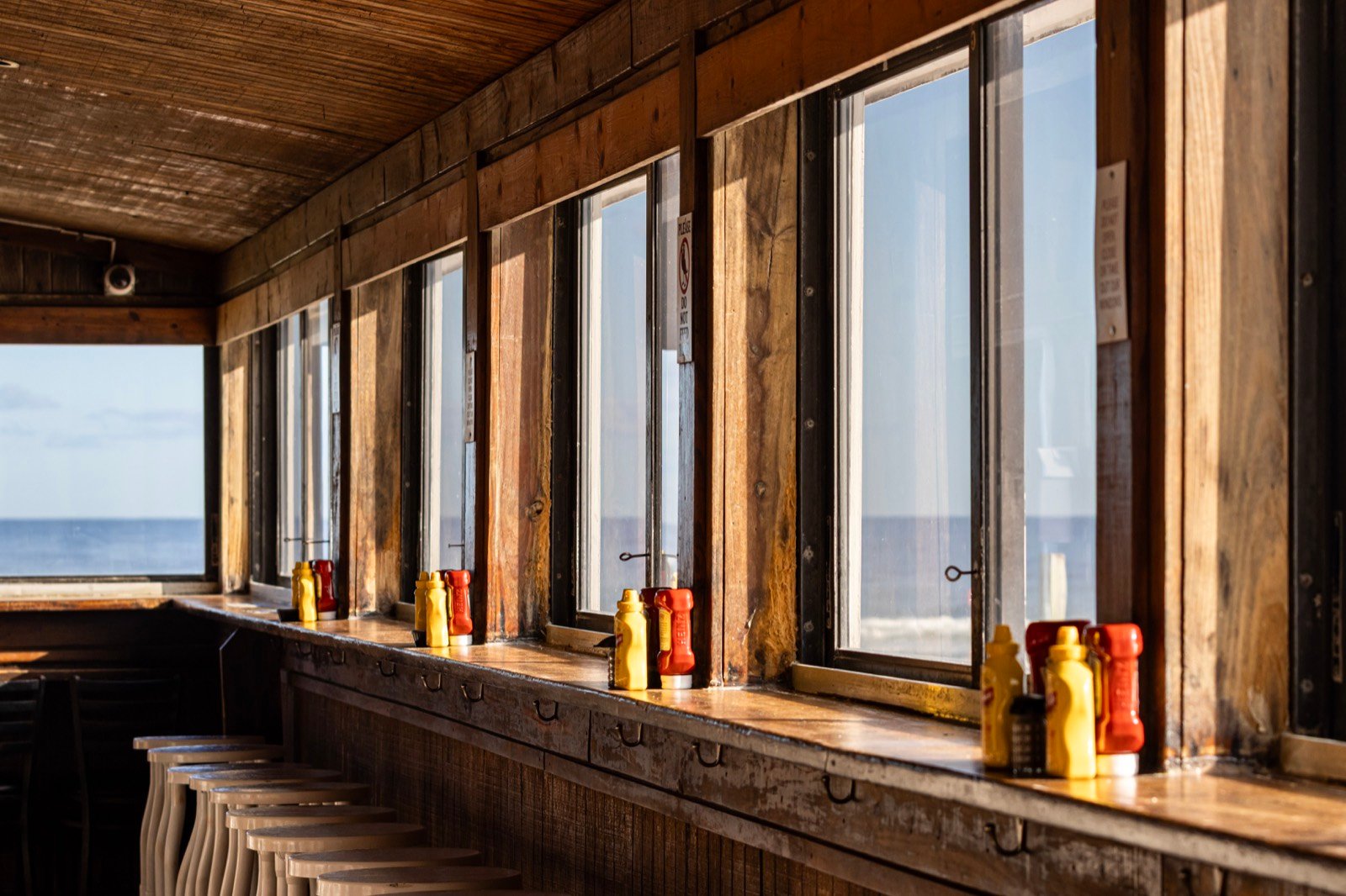 Oceanfront bar seating at The Breakers with a view of the water through every window